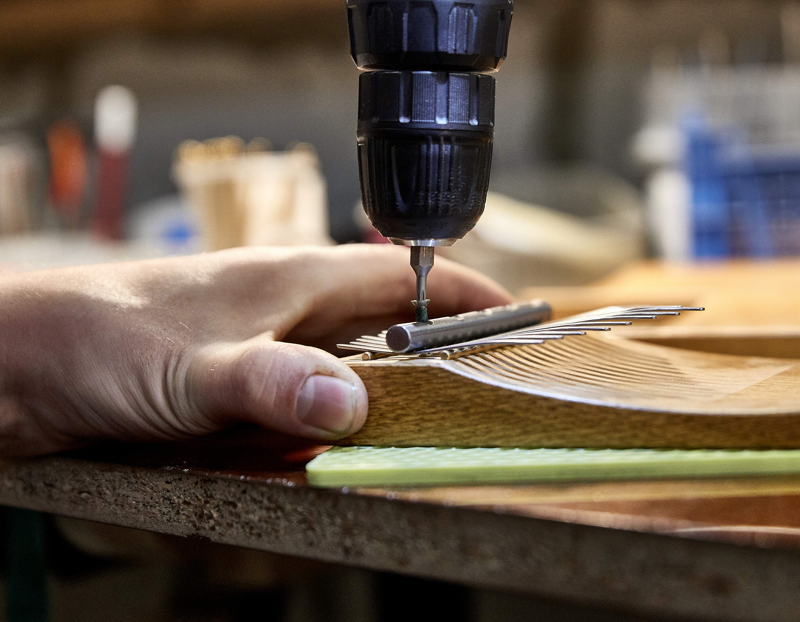Hands at work shaping and finishing musical instruments